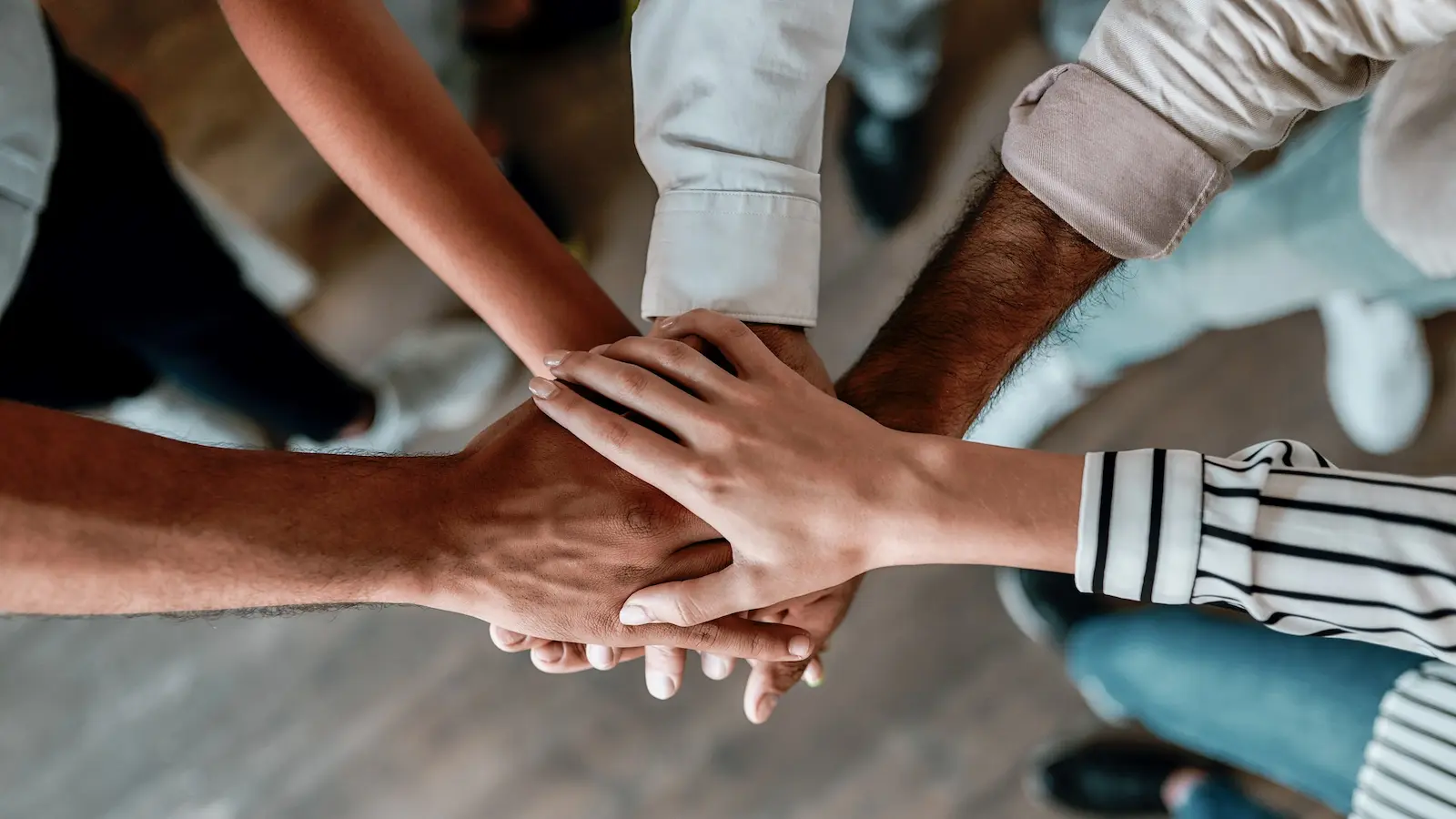 Equipo de personal apoyando una mano sobre otra